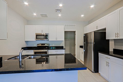 a modern kitchen with stainless steel appliances and black counter tops
